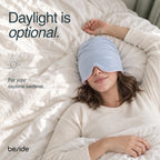 Person resting in bed during daylight while wearing the Blushing Sky Sleep Hood.