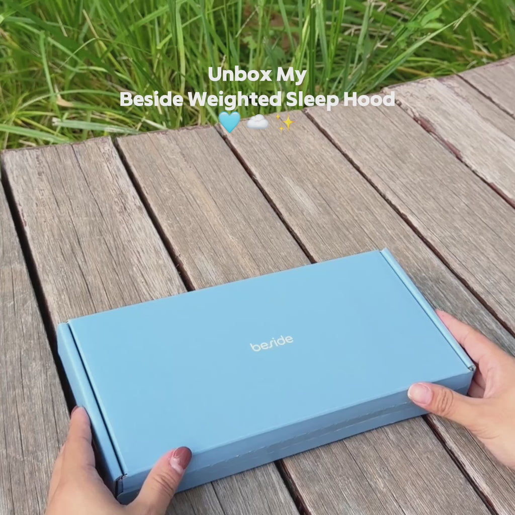 Blue Beside Sleep Hood box on a wooden table beneath an unboxing video caption.